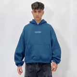 Buzo hoodie verde oscuro con corte boxy y logo estampado en el pecho.