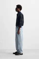 Pantalón de jean celeste de corte recto, con cinco bolsillos, efecto lavado y cierre frontal con botones.