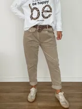 Pantalón color beige de corte ligeramente suelto, confeccionado en algodón y elastano. Incluye un cinto de animal print.