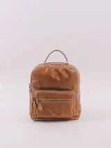 Mochila de cuero color marrón con cierre superior y bolsillo frontal con cierre. Interior forrado con bolsillo con cierre, bolsillo abierto y llavero. Cuenta con asa superior y correas ajustables para los hombros.