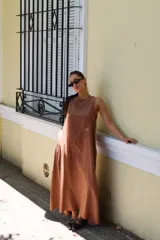 Vestido largo gris sin mangas, con escote redondo, bolsillos laterales y logo bordado en el frente.