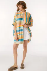 Camisa oversize con cuello mao, manga corta con terminación en puño, botones de metal a la vista y tajos laterales.