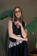 Lentes de sol negros con marco rectangular y lentes amarillas.