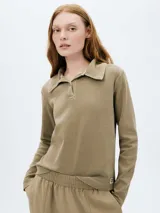 Camiseta tipo polo color beige, de manga larga y corte recto.