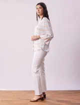 Blusa estampada a rayas horizontales en tonos celeste, blanco y naranja, con cuello mao, escote en V y abertura con botones. Delantero con punto smock. Manga ¾ con terminación amplia.