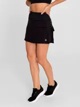 Falda deportiva negra con calza interior, de secado rápido. Diseño acampanado con plisado en la parte trasera, pretina ancha con bolsillo con cierre y bolsillo interior en la calza.