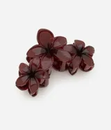 Pinza para el pelo color borgoña con forma de tres flores juntas. Accesorio de plástico y metal.