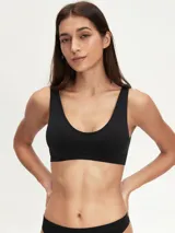 Top deportivo negro sin costuras, con breteles anchos y escote redondo.