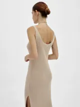 Vestido largo tejido en jersey color beige, con escote bote y corte con abertura en los laterales.