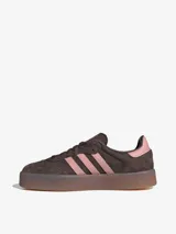 Zapatillas Adidas modelo Sambae, color marrón con detalles en rosa. Confeccionadas en cuero con refuerzos texturizados en la puntera y cordones. Suela de caucho color caramelo con dibujo multidireccional.