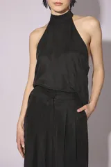 Conjunto de blusa y pantalón color gris azulado de seda, con cuello halter y corte holgado.
