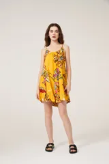 Vestido corto amarillo con estampado de flores, breteles finos y cuello redondo.