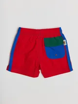 Short de baño azul con cintura elástica, rayas verdes en los laterales y bolsillo trasero con solapa roja y verde.