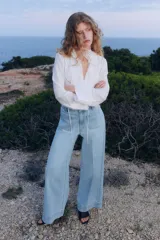 Pantalón de jean celeste de pierna ancha, tiro alto, con bolsillos de parche delanteros y traseros.