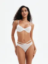 Conjunto de bikini blanco de tela brillante, compuesto por un corpiño con aro y breteles finos y una bombacha con tiras cruzadas en la cadera.