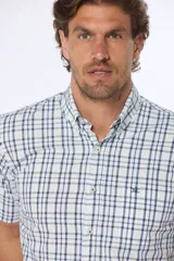 Camisa de manga corta con cuello abotonado y estampado a cuadros en tonos verde y blanco. Hecha en Uruguay.