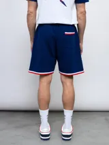 Bermuda deportiva azul con cintura elastizada ajustable con cordón, bolsillos laterales y escudo del Club Nacional de Football estampado en la pierna izquierda.