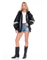 Campera negra de cuero sintético con capucha oversize, cierre frontal y detalles de franjas blancas en las mangas y a lo largo del cierre. Cuenta con bolsillos frontales con solapa y puños elásticos.