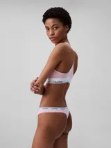 Conjunto Calvin Klein de ropa interior deportiva, compuesto por un corpiño con espalda racerback y una colaless, ambos en color rosado con elástico blanco con el logo de la marca.