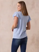 Blusa blanca de tejido pointelle con escote en V y aplique de puntilla en el cuello y mangas cortas con volados.