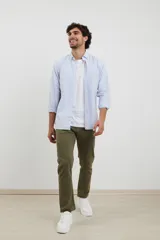 Camisa a rayas celeste y blanca, de corte deportivo con botones frontales y manga larga.