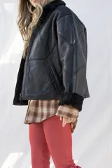 Campera gamulán de cuero negro con cuello y puños de piel sintética negra.