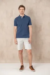 Remera tipo polo color beige, de manga corta y corte clásico. Tiene cuello con botones y está confeccionada en algodón.