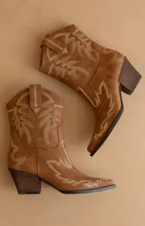 Bota corta de cuero color marrón con bordados en color crema, taco bajo y punta fina. De estilo tejano.