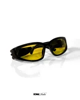 Lentes de sol negros con lentes amarillas, protección UV 400 y diseño envolvente.