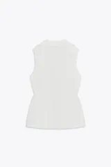 Chaleco blanco de tejido de punto con cuello solapa, sin mangas, detalle de elástico en la cintura y cierre frontal con botones metálicos.