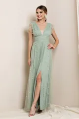 Vestido largo de fiesta color verde agua, con escote en V, mangas cortas con volados de tul y falda con abertura lateral. El vestido está confeccionado en tul bordado con pequeñas estrellas plateadas.