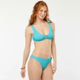 Top de bikini celeste con textura gofrada y aro metálico en el centro.