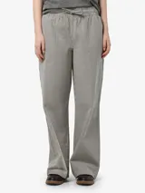 Pantalón cargo de tiro medio con estampado a rayas verticales en tonos beige y negro. Confeccionado en algodón, con bolsillos delanteros y traseros, cintura elástica con cordón ajustable.