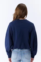 Buzo azul marino de corte holgado con mangas abullonadas y cuello redondo.