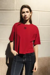 Remera negra de algodón con corte cuadrado, cuello redondo y logo bordado en color naranja.