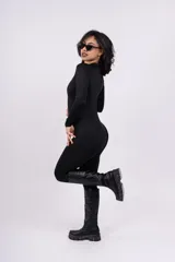 Mono largo negro ajustado al cuerpo con cierre frontal y cuello alto.