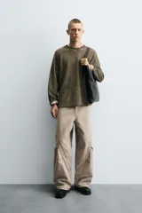 Pantalón de jean color beige, corte holgado y amplio en toda la pierna, tiro medio, tejido rígido, cinco bolsillos, efecto lavado y detalle de pinzas en perneras.