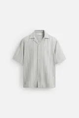 Camisa de manga corta con cuello bowling y corte relaxed fit, confeccionada en tejido con algodón y diseño a rayas verticales en tonos beige y blanco.