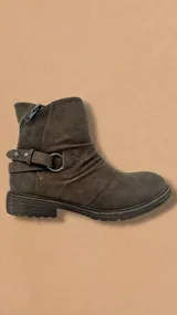 Bota corta color marrón con hebilla y detalle de argolla metálica.