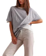 Remera gris de corte cuadrado, ligeramente extragrande, con escote redondo, hombros caídos y costuras sin rematar.