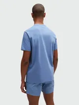 Remera de manga corta, cuello redondo, color gris claro o blanco roto, con el logo "BOSS" estampado en blanco en el pecho.