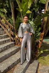 Pantalón plateado de lamé elastizado, corte palazzo y tiro alto.