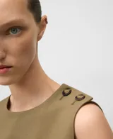 Top recto sin mangas, color verde oliva, con cuello redondo y cierre de dos botones en el hombro izquierdo. Presenta aberturas laterales en el delantero.