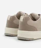 Championes urbanos color beige, confeccionados en material sintético, con recortes laterales, cordones y suela alta con detalles contrastantes.