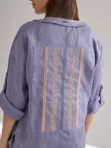 Camisa color coral de lino, corte holgado, escote redondo y mangas 3/4 ajustables con botón.