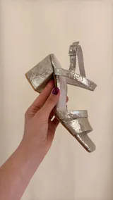 Sandalia dorada de cuero con doble tira delantera, horma cuadrada y ajuste con hebilla.