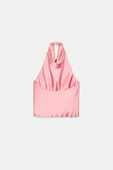 Top blanco satinado con cuello halter y escote fluido. Cierre en la espalda con botones.