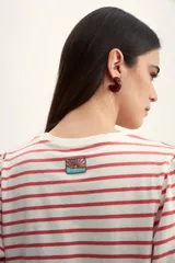 Remera de manga corta con cuello redondo y estampado de rayas horizontales blancas y negras. Mangas abullonadas con puño blanco.