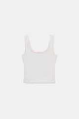 Top negro de corte ajustado, con escote redondo y tirantes anchos. Presenta un diseño de superposición de telas.