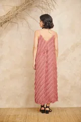 Vestido largo color rosa viejo, con breteles finos y escote en V. Presenta flecos diagonales en toda la prenda.